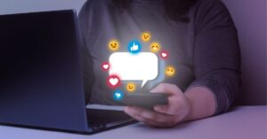 Person using a smartphone with social media icons floating around.