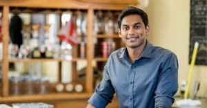 Smiling professional in a casual shirt in an office setting.