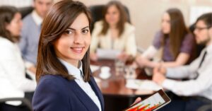 Confident professional holding a tablet, leading a team meeting.