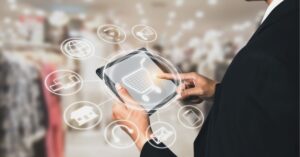 Person using a tablet with digital shopping icons overlay.