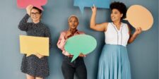 Three women holding colorful speech bubbles.