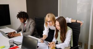 Team collaborating at a desk, titled "Developing Employees: 15 Smart Ways to Drive Growth."