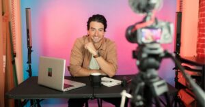 Man smiling at camera, preparing for a video recording.
