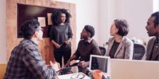 Team meeting with a woman leading a discussion.