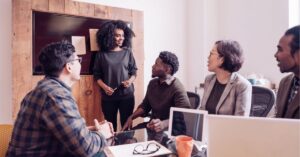 Team meeting with a woman leading a discussion.