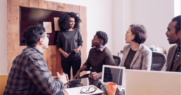 Team meeting with a woman leading a discussion.