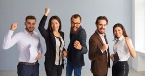 Team celebrating success with fists raised, showing excitement and achievement.