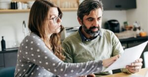 Two colleagues discussing content at a desk. Text: "Content Curation: What You Need to Know Today. www.techhelp.ca."