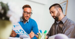 Two professionals discussing a financial report in an office.