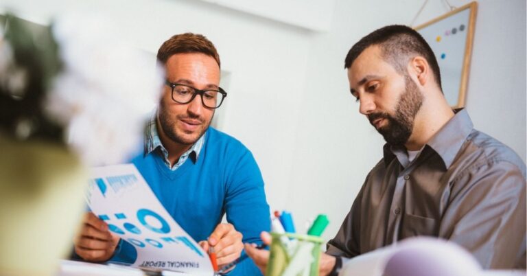 Two professionals discussing a financial report in an office.