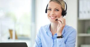 Smiling customer support representative wearing a headset, ready to assist.