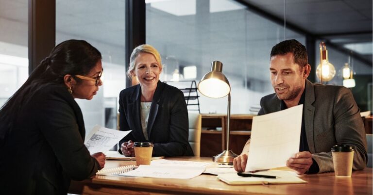 Team of professionals reviewing documents in a meeting room.