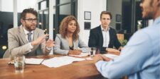 Business team in a meeting, engaged in a discussion around a table.