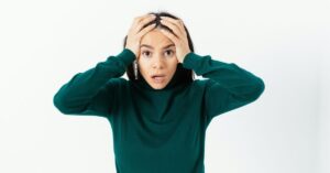 Stressed business owner holding her head, illustrating the need for a small business disaster recovery plan.