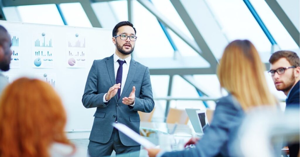 Professional man presenting data to colleagues in a conference room.