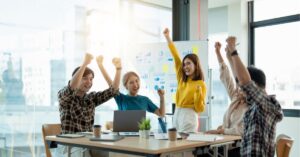 Team celebrating success in a bright office space.