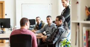Team of professionals in a casual meeting in an office setting.