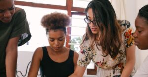 Small team collaborating at a table, reviewing notes and discussing a new business idea.