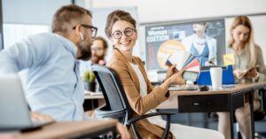 Team discussion in an office as a woman shows a fan of color swatches to a coworker
