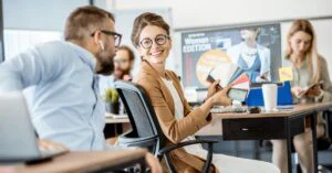 Team discussion in an office as a woman shows a fan of color swatches to a coworker