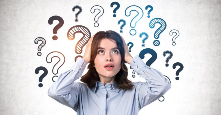 Woman holding her head with multiple question marks floating around her on a light background.