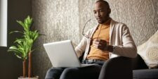 Man sitting in a chair and looking at a laptop, used as the featured image for a free outline generator article.