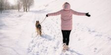 What Your Digital Footprint Reveals and How to Minimize It Person in a pink winter jacket walking a dog on a snowy path with visible footprints, symbolizing the traces people leave behind online