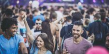 Escapism in Marketing: Create Emotional Relief Without Losing Trust A lively outdoor crowd of young adults smiling and dancing at a music festival, illustrating escapism in marketing.
