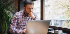 The Search Traffic You Lost Didn't Go to a Competitor — It Went to Google Business owner looking at a laptop, representing how Google AI Overviews may affect buying searches, website traffic, and online visibility.
