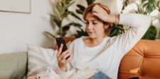 Your Website Traffic Is Lying to You Concerned woman looking at her phone while sitting on a couch, representing confusing or misleading website traffic data