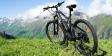 7 Cheap eBikes Under $1,000 That Won't Leave You Stranded Electric mountain bike parked on grass with mountains in the background