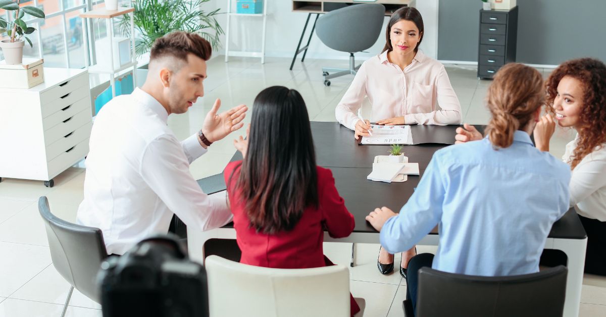 Business professionals meeting around a conference table in a bright office.