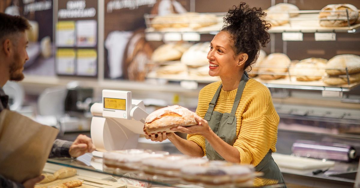 Bakery employee serving a customer, representing a small business using an SEO audit to improve website visibility and attract more local traffic.