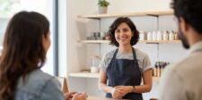Alt text: Small business owner speaking with customers inside a bright retail shop.
