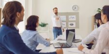 Why Canadian Organizations Are Moving to Secure Board Member Portals to Meet PIPEDA and Governance Requirements Business professional presenting charts and graphs to a team seated around a conference table with laptops in a modern office setting