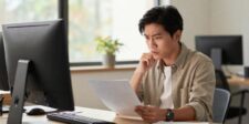Shopify's vape ban is a warning for every online seller Man reviewing a document at his desk with a concerned expression, representing online sellers facing platform policy changes.
