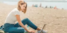 The WordPress Security Gap That Quietly Kills Growth Person sitting on a beach and working on a laptop.