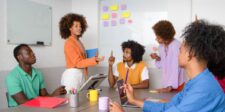 Google launches AI Overviews in France after publisher standoff Team discussing ideas in a meeting room with sticky notes on a whiteboard.