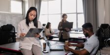 Canada's intelligence agencies say AI cyberattacks are months away — one group is already stealing Canadian paycheques Team members working in an office with laptops and notes, representing business teams preparing for cybersecurity risks.