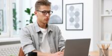 Copywriting Hooks: 15 Proven Types With Templates You Can Steal Man wearing glasses and working on a laptop at a desk.
