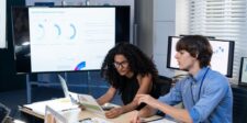Google Search Console now tracks social content beyond your website Two people reviewing marketing analytics on a large screen in an office.