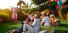 What July 4th spending says about where your customers are headed Family and friends gathered outside for a sunny backyard celebration with food, balloons, flags, and festive decorations.