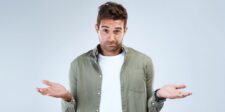 SharePoint is under siege: what recent attacks mean for your business Man in a green shirt shrugging against a light gray background.