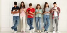 Tech habits single-parent founders can use to keep their kids safe (without spyware drama) Six teenagers standing against a wall while looking at their phones and tablets.