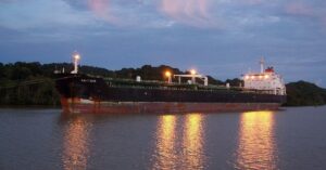 Cargo ship traveling through the Panama Canal at dusk