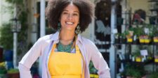 Canada's economy is growing again, but should your business expand right now? Smiling small business owner standing outside a garden shop.