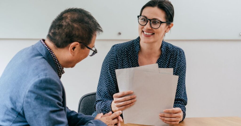 Two business professionals reviewing documents together during a meeting.