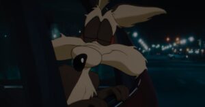 Wile E. Coyote sitting in a car at night in a scene from Coyote vs. Acme.