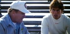 Two men talking beside racetrack bleachers in a scene from Days of Thunder.