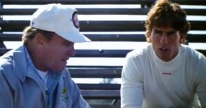 Two men talking beside racetrack bleachers in a scene from Days of Thunder.
